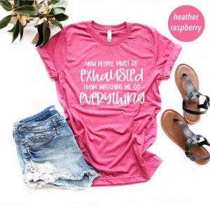 May include: Heather raspberry t-shirt with the text "You people must be exhausted from watching me do everything".