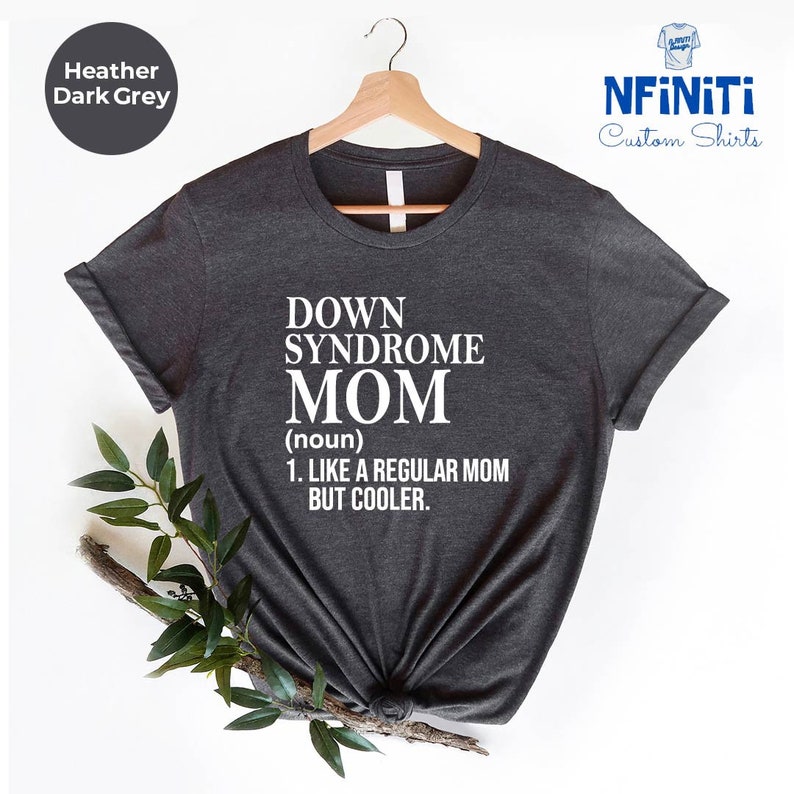 Puede incluir: Camiseta gris oscuro jaspeada con texto blanco que dice "Down Syndrome Mom (sustantivo) 1. Como una madre normal pero m&aacute;s cool."