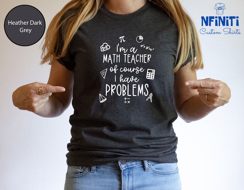 May include: Heather dark grey t-shirt with a white graphic that says "&pi; I'm a MATH TEACHER of course I have PROBLEMS". The graphic includes math symbols like a pie chart, a calculator, a compass, and a triangle.