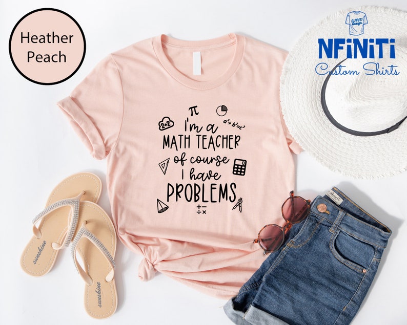 May include: A pink t-shirt with a black graphic that says "I'm a math teacher of course I have problems". The graphic includes math symbols like pi, a calculator, and a protractor.