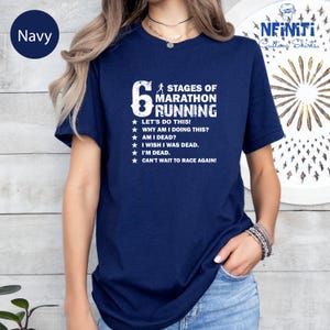 a woman wearing a navy blue t - shirt with a six stages of marathon running