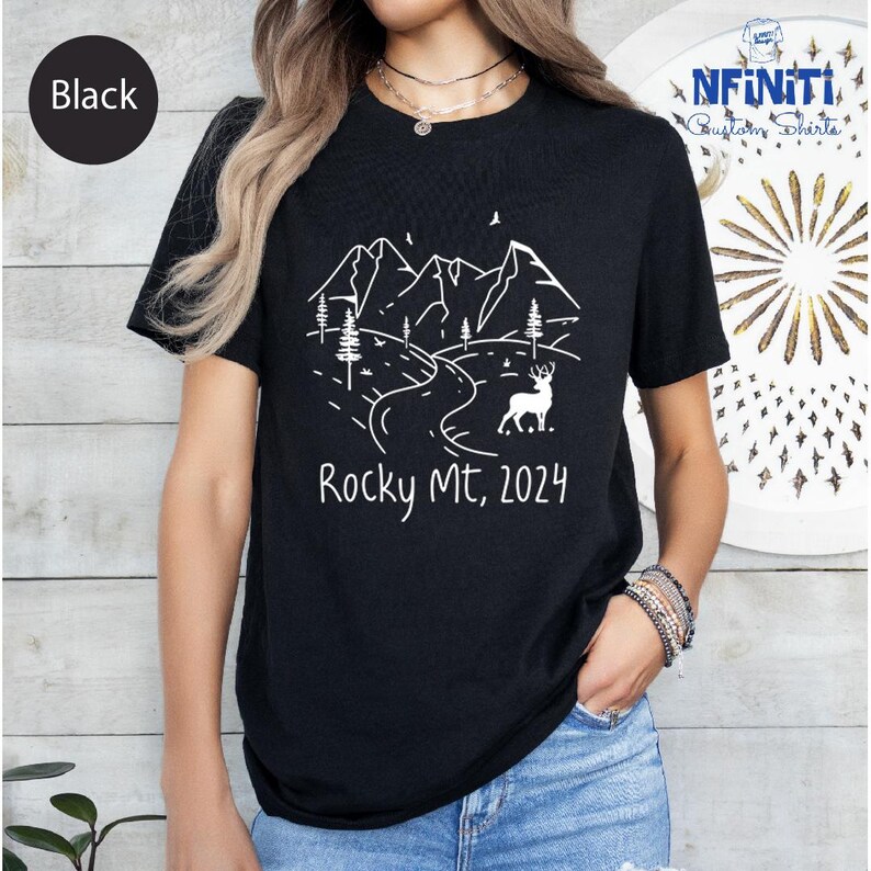 a woman wearing a black rocky mtn t - shirt