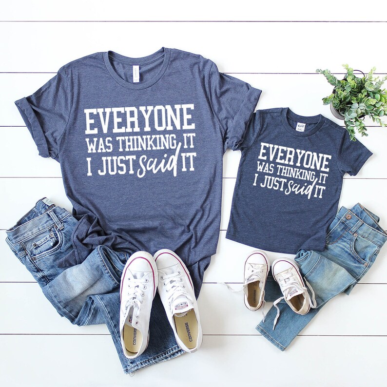 Pode incluir: Camisetas combinando azul marinho com texto branco. A camiseta de adulto diz "Everyone was thinking, it I just said it". A camiseta de crian&ccedil;a diz "Everyone was thinking, it I just said it".