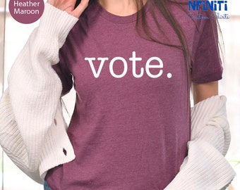 May include: A heather maroon t-shirt with the word "vote" printed in white on the front.