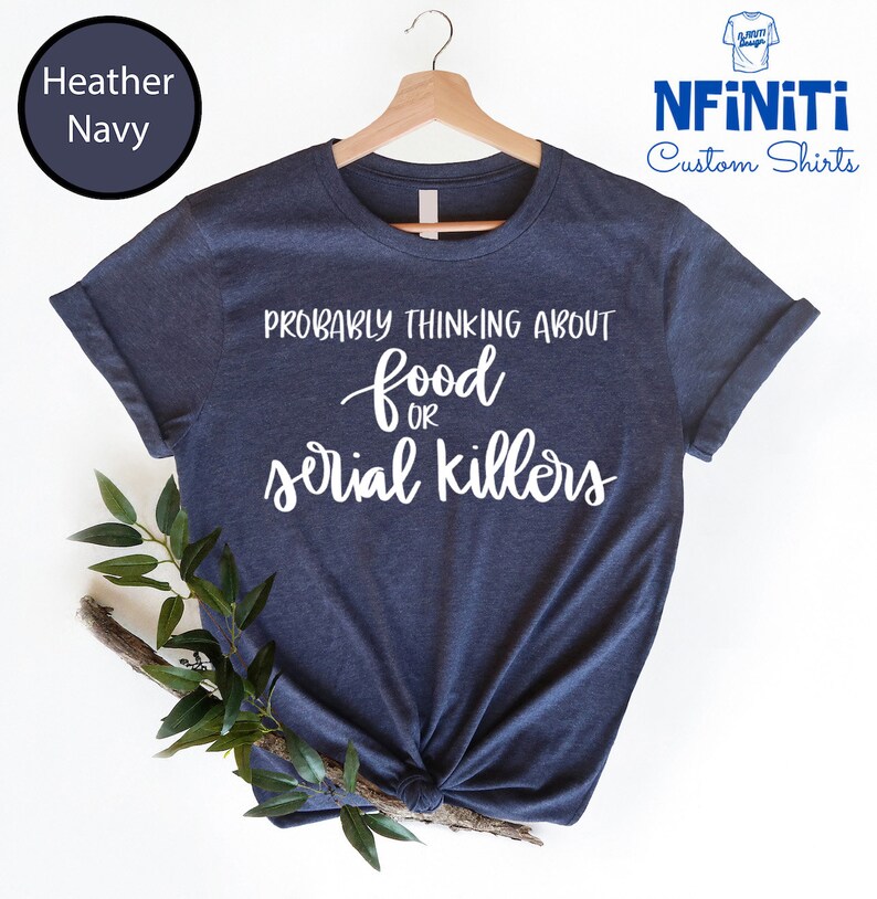 May include: A heather navy blue t-shirt with the text "Probably thinking about food or serial killers" in white script.