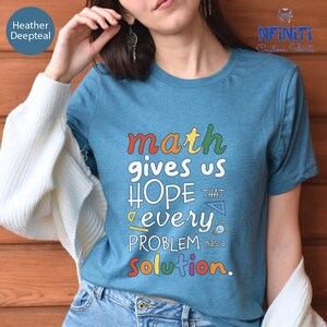 a woman wearing a t - shirt that says math gives us hope every problem solution