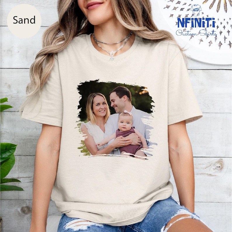 a woman wearing a t - shirt with a picture of a man and a baby