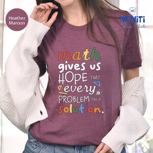 a woman wearing a t - shirt that says math gives us hope that every problem