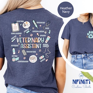 Peut inclure: T-shirt bleu marine chiné avec un motif représentant un chat et divers rôles et responsabilités d'assistant vétérinaire. Le texte "Veterinary Assistant" est au centre du motif.