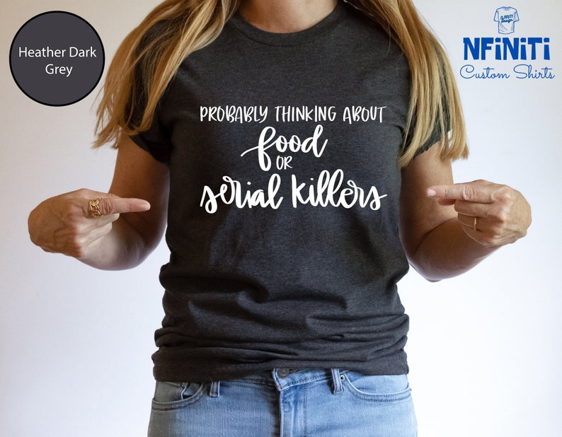 May include: A heather dark grey t-shirt with the text "Probably thinking about food or serial killers" in white lettering.