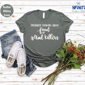May include: A heather military green t-shirt with the text "Probably thinking about food or serial killers" in white.