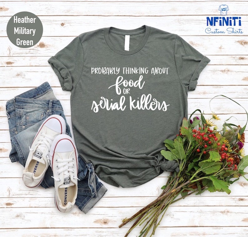 May include: A heather military green t-shirt with the text "Probably thinking about food or serial killers" in white.
