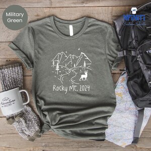 a t - shirt with a picture of a mountain and a deer on it
