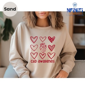 May include: A beige sweatshirt with a red heart design and the text "CHD awareness".
