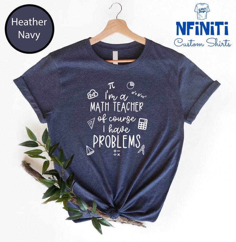 May include: A navy blue t-shirt with a white graphic that says "I'm a math teacher of course I have problems" with math symbols surrounding the text.