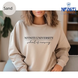 May include: A sand-colored sweatshirt with the text "NFINITI UNIVERSITY school of nursing" printed on the front.