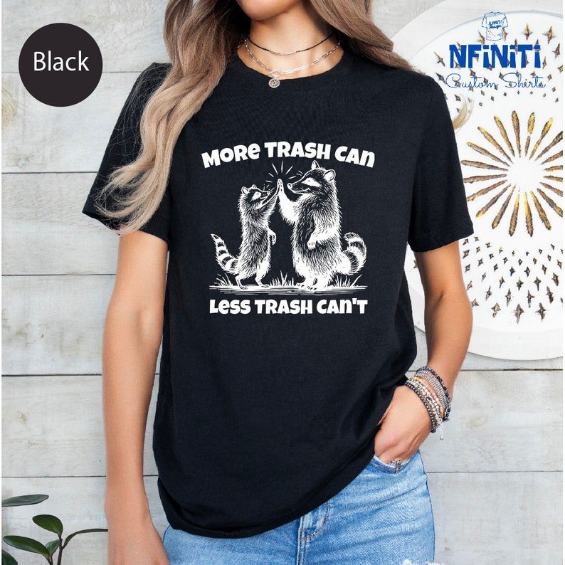 a woman wearing a black t - shirt that says more trash can less trash can