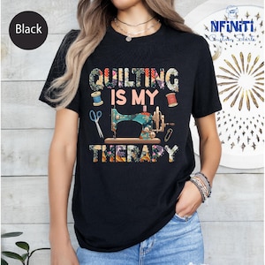 Pode incluir: Camiseta preta com um gráfico de máquina de costura colorido e o texto "Quilting is my therapy".