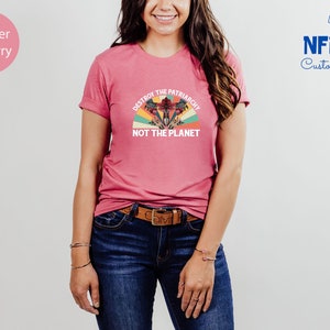 May include: A heather raspberry t-shirt with a vintage-style graphic that says "Destroy the Patriarchy, Not the Planet".