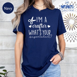 a woman wearing a navy t - shirt that says i'm a crafter