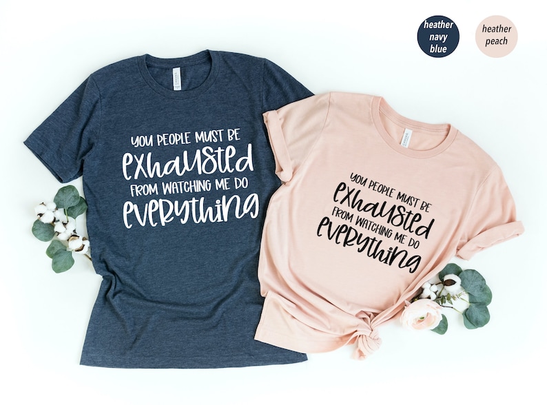 May include: Two t-shirts with the text "You people must be exhausted from watching me do everything" in black lettering on a heather navy blue and heather peach shirt.
