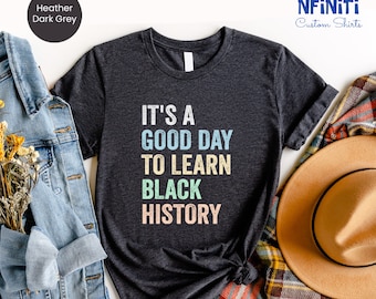 May include: A heather dark grey t-shirt with the text "It's a good day to learn Black History" in colorful letters.