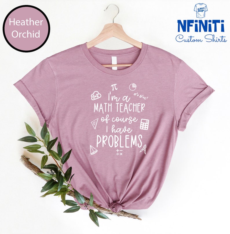 May include: A heather orchid t-shirt with a white graphic that says "I'm a math teacher of course I have problems" with math symbols and equations.