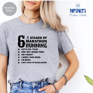 a woman wearing a grey t - shirt that says stages of marathon running