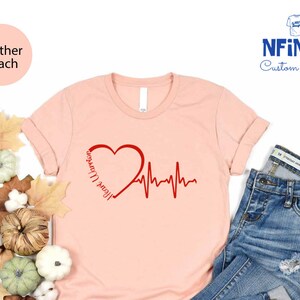 a pink shirt with a heart and heartbeat on it