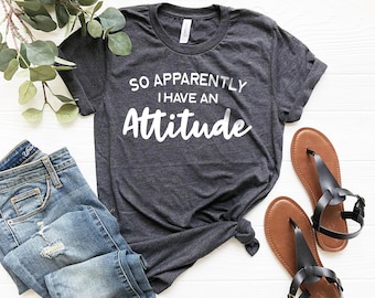 May include: A dark heather grey t-shirt with the text "So Apparently I Have An Attitude" printed in white.