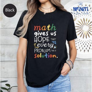 a woman wearing a black t - shirt that says math gives us hope that every