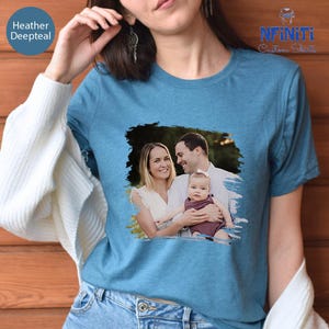 a woman wearing a blue t - shirt with a picture of a man and a