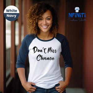 May include: A white and navy blue baseball tee shirt with the text "Don't Miss Chance" printed in black on the front.
