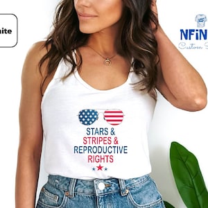May include: White tank top with a graphic of sunglasses with an American flag design. The text "Stars & Stripes & Reproductive Rights" is printed below the sunglasses.