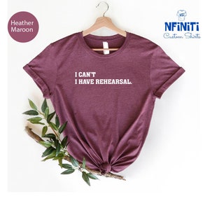 May include: Heather maroon t-shirt with the text "I CAN'T I HAVE REHEARSAL." printed in white.