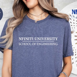 May include: A heather navy blue t-shirt featuring the white text "NFINITI UNIVERSITY SCHOOL OF ENGINEERING". The shirt has a crew neck design. The brand name "NFINITI Custom Shirts" is visible in the upper right corner.