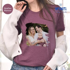 a woman wearing a t - shirt with a picture of a man holding a baby