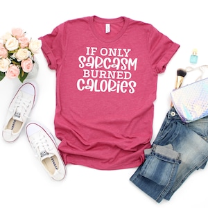 May include: A pink t-shirt with the text "If only sarcasm burned calories" in white lettering.