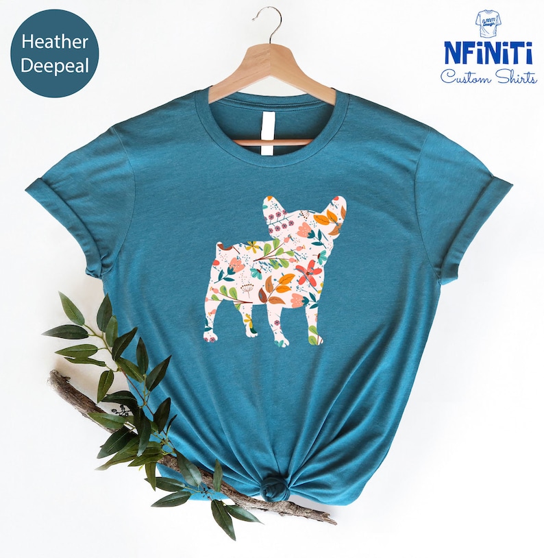 Peut inclure: Un t-shirt bleu sarcelle avec un motif floral &agrave; l'int&eacute;rieur de la silhouette d'un bouledogue fran&ccedil;ais. Le texte "NFINITI Custom Shirts" est dans le coin sup&eacute;rieur droit de l'image.
