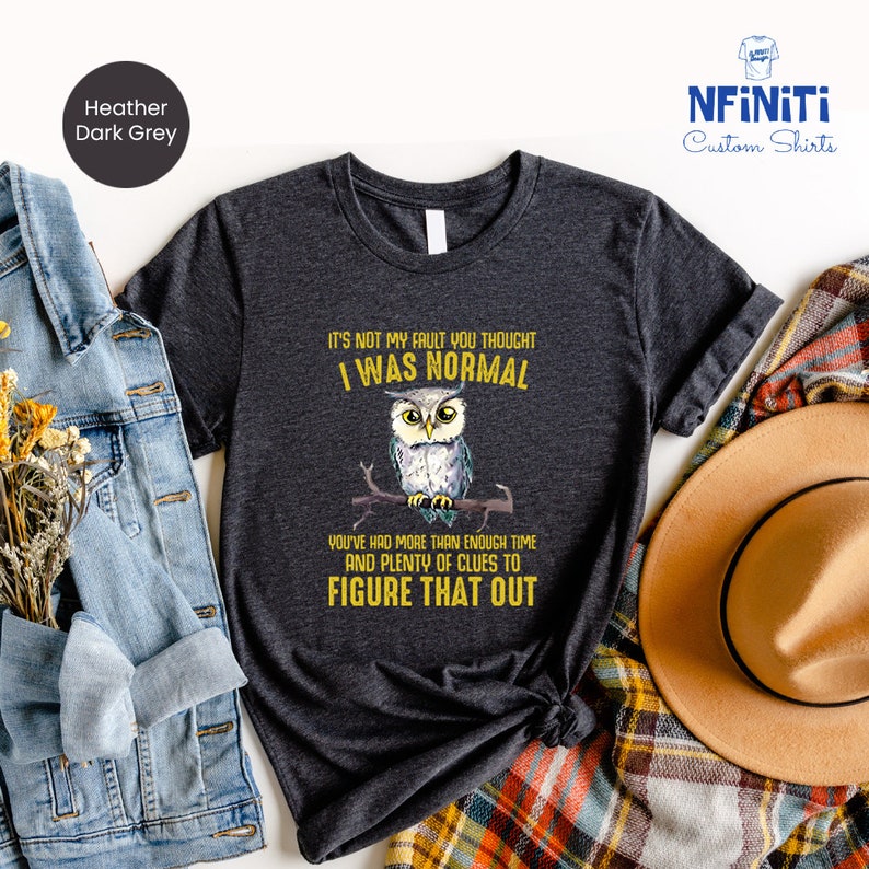Puede incluir: Camiseta gris oscuro jaspeada con un gr&aacute;fico de un b&uacute;ho y el texto "No es mi culpa que pensaras que era normal. Has tenido m&aacute;s que suficiente tiempo y muchas pistas para entenderlo."