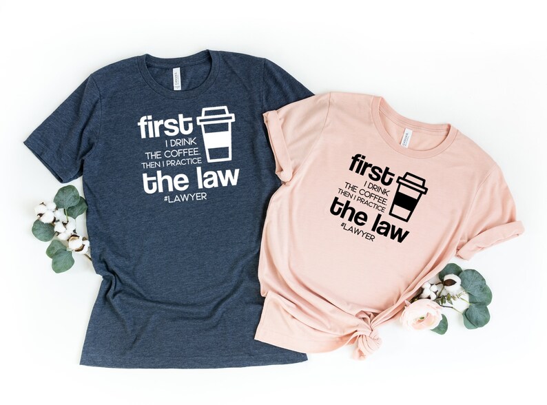 以下が含まれることがあります： コーヒーカップのグラフィックと「first I drink the coffee then I practice the law #LAWYER」というテキストが書かれたTシャツ2枚。