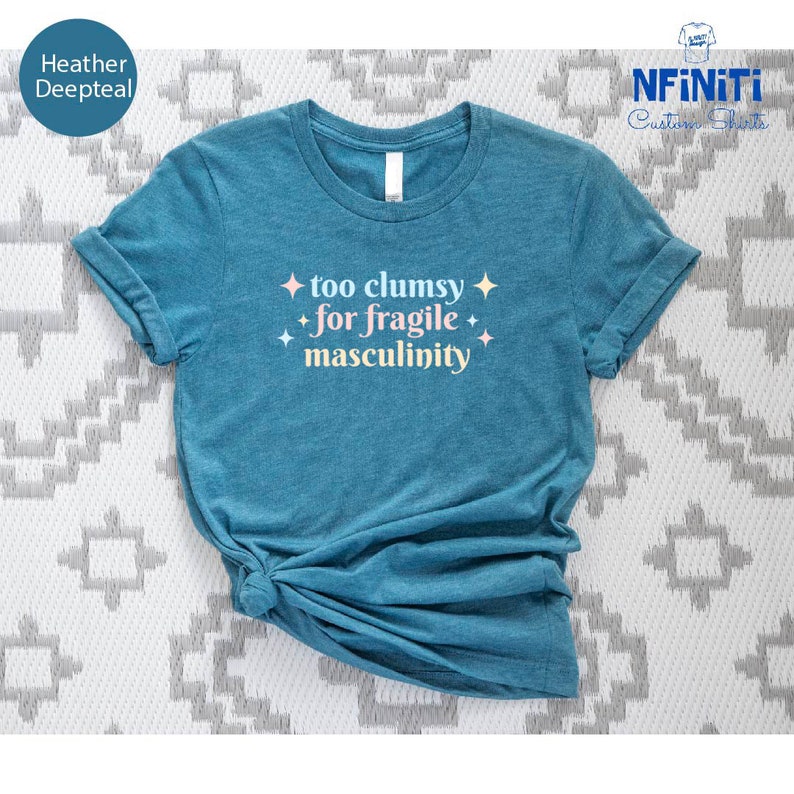a blue t - shirt that says too chummy for fragile masculiniity