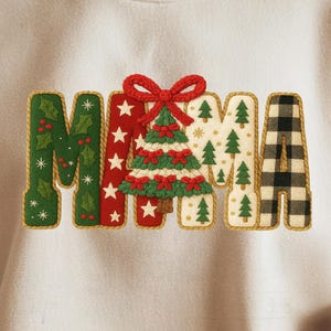 Könnte beinhalten: Cremefarbenes Sweatshirt mit dem Wort "MAMA" in einem festlichen Weihnachtsdesign. Die Buchstaben sind mit Stechpalmen, Sternen, einem Weihnachtsbaum und Büffelkaros verziert. Eine Person hält eine Tasse.