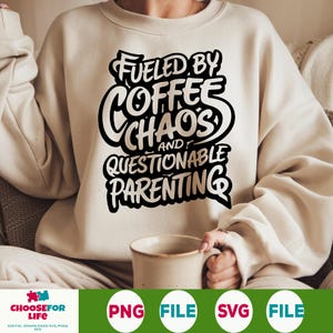 Puede incluir: Sudadera color crema con el texto "Fueled by Coffee, Chaos, and Questionable Parenting" en negro. La persona sostiene una taza beige. La sudadera es de estilo casual y cómodo.