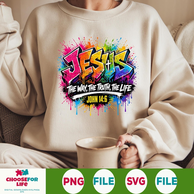 May include: A beige crewneck sweatshirt featuring a colorful graffiti-style graphic that reads JESUS THE WAY, THE TRUTH, THE LIFE and JOHN 14:6. The design includes vibrant paint splatters in pink, blue, yellow, and green surrounding the text.