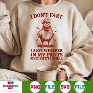 May include: Cream-colored sweatshirt with a red cartoon chicken graphic and the text "I DON'T FART, I JUST WHISPER IN MY PANTS SOMETIMES ITS A SCREAM." The design features a whimsical chicken illustration.