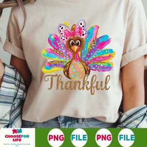 May include: A colorful Thanksgiving turkey with a pink bow and glitter accents. The text "Thankful" is written in gold glitter below the turkey.