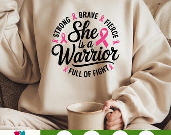 May include: A beige sweatshirt with a pink ribbon design and the text "Strong & Brave & Fierce & She is a Warrior & Full of Fight &"