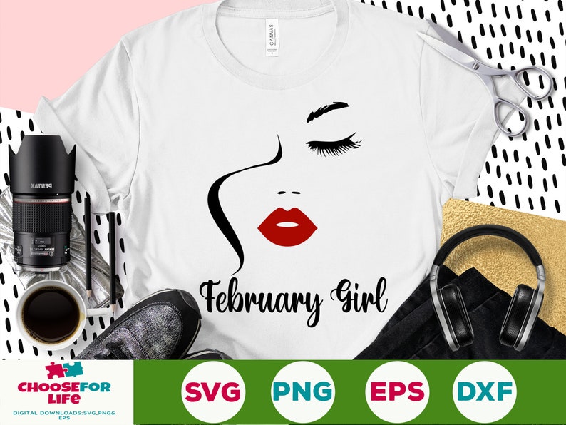Puede incluir: Camiseta blanca con un gr&aacute;fico de un rostro femenino, labios rojos y el texto "February Girl" en negro. El dise&ntilde;o incluye un contorno negro del rostro y pesta&ntilde;as. La camiseta est&aacute; rodeada por una c&aacute;mara, tijeras y auriculares.