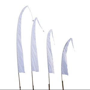 May include: Four white fabric flags on wooden poles, arranged in descending size order. The flags are all white and have a slightly curved shape.